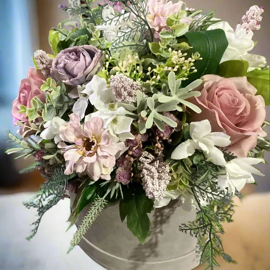 A flower arrangement of ivory hydrangea & pink roses in hatbox