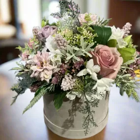 A flower arrangement of ivory hydrangea & pink roses in hatbox