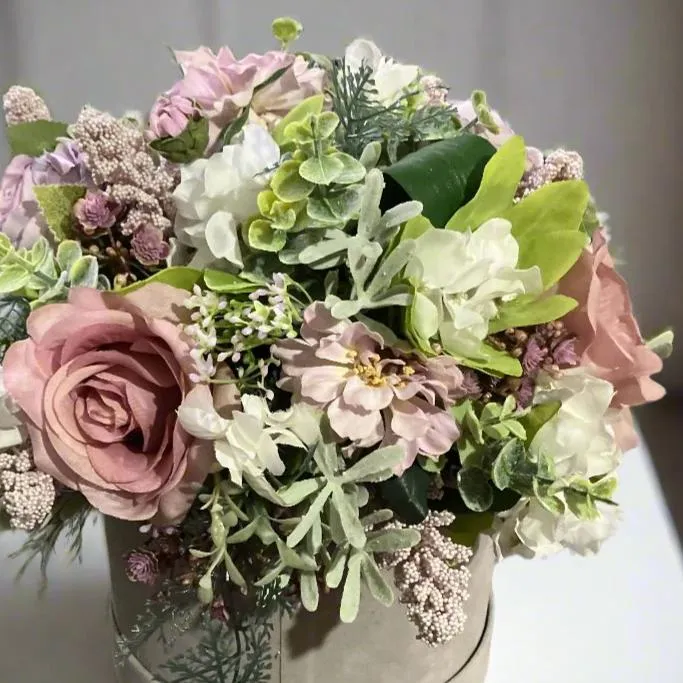 A flower arrangement of ivory hydrangea & pink roses in hatbox